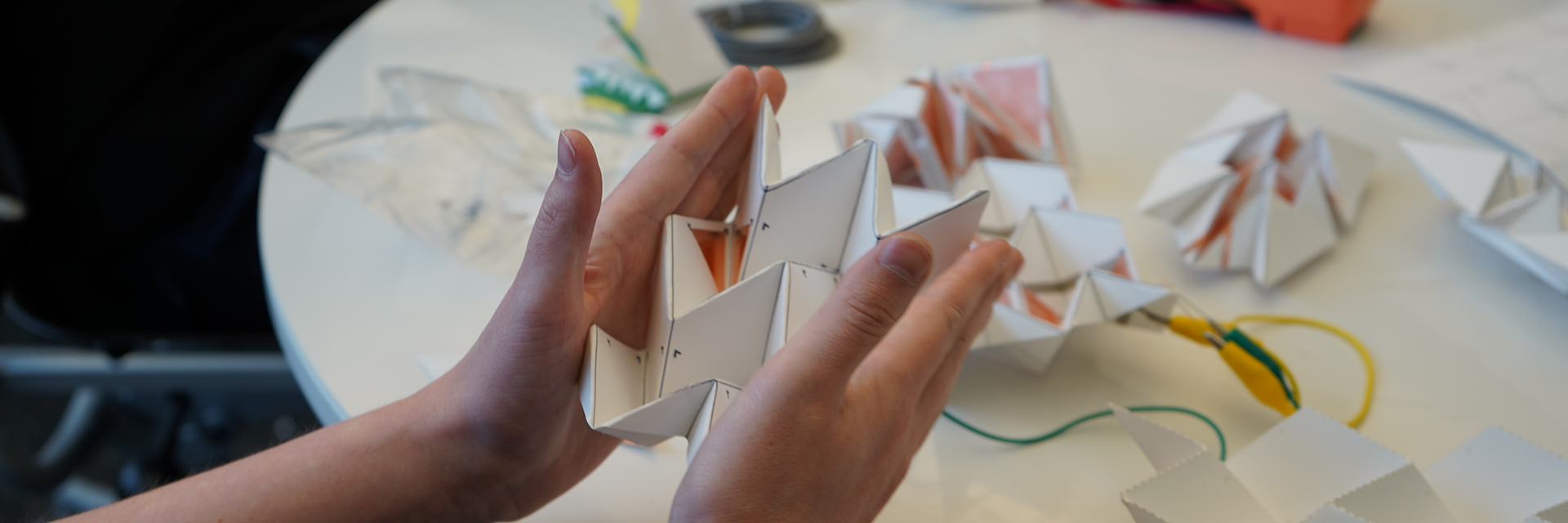 Hands squeezing power generating origami. 
