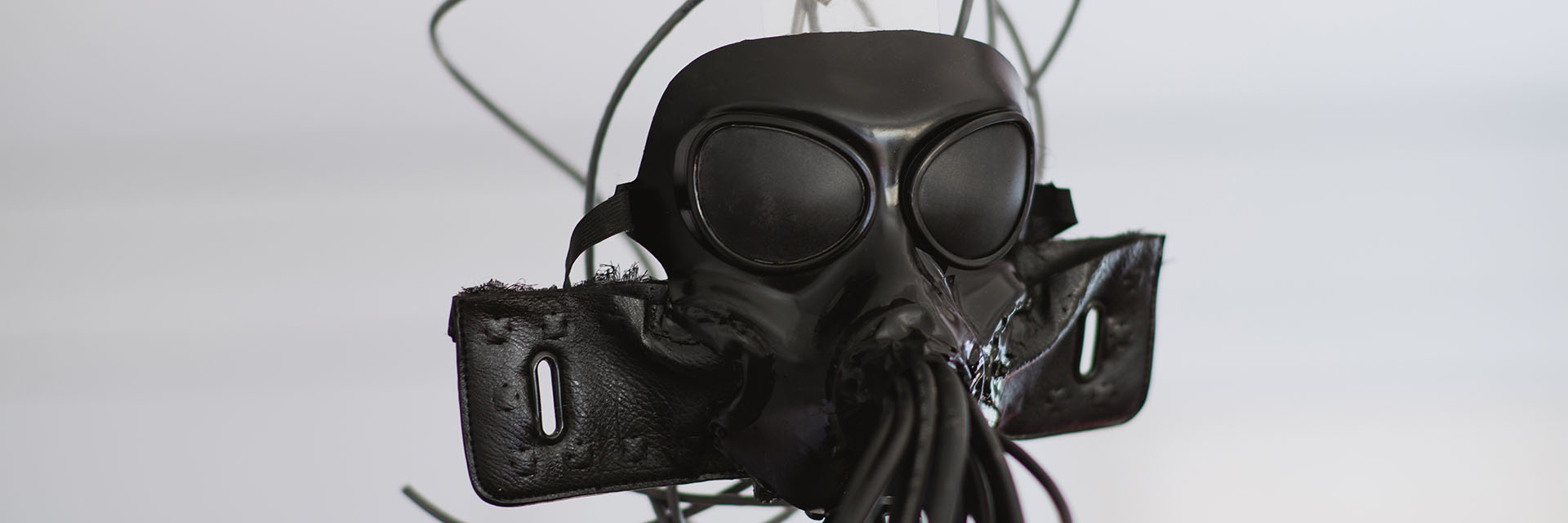 face mask that looks like a gas mask but with many wires coming out of it. 