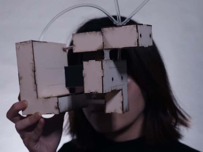 A device made of a series of boxes being held to the face